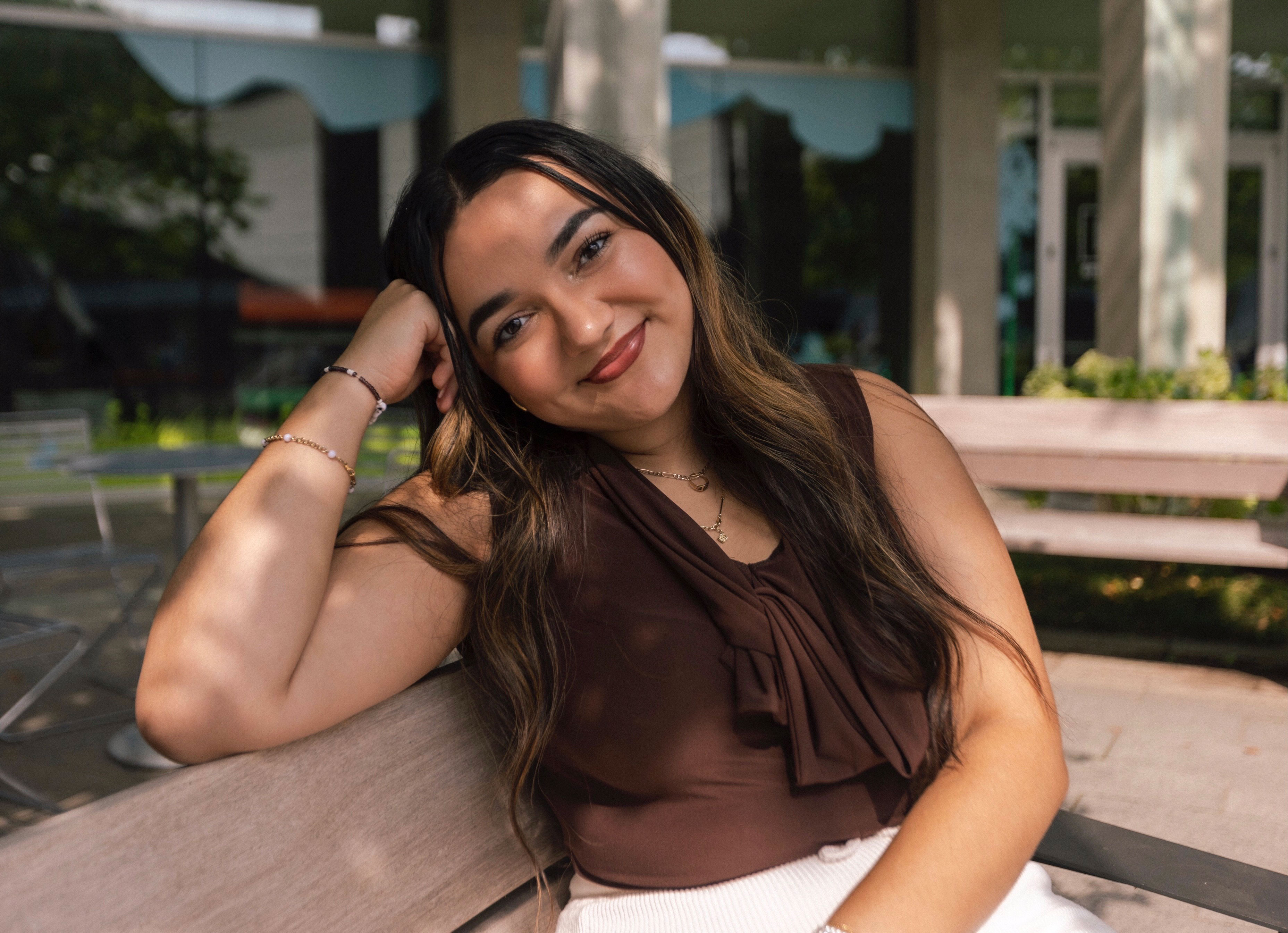 Jasmine Rosa sitting on a bench smiling