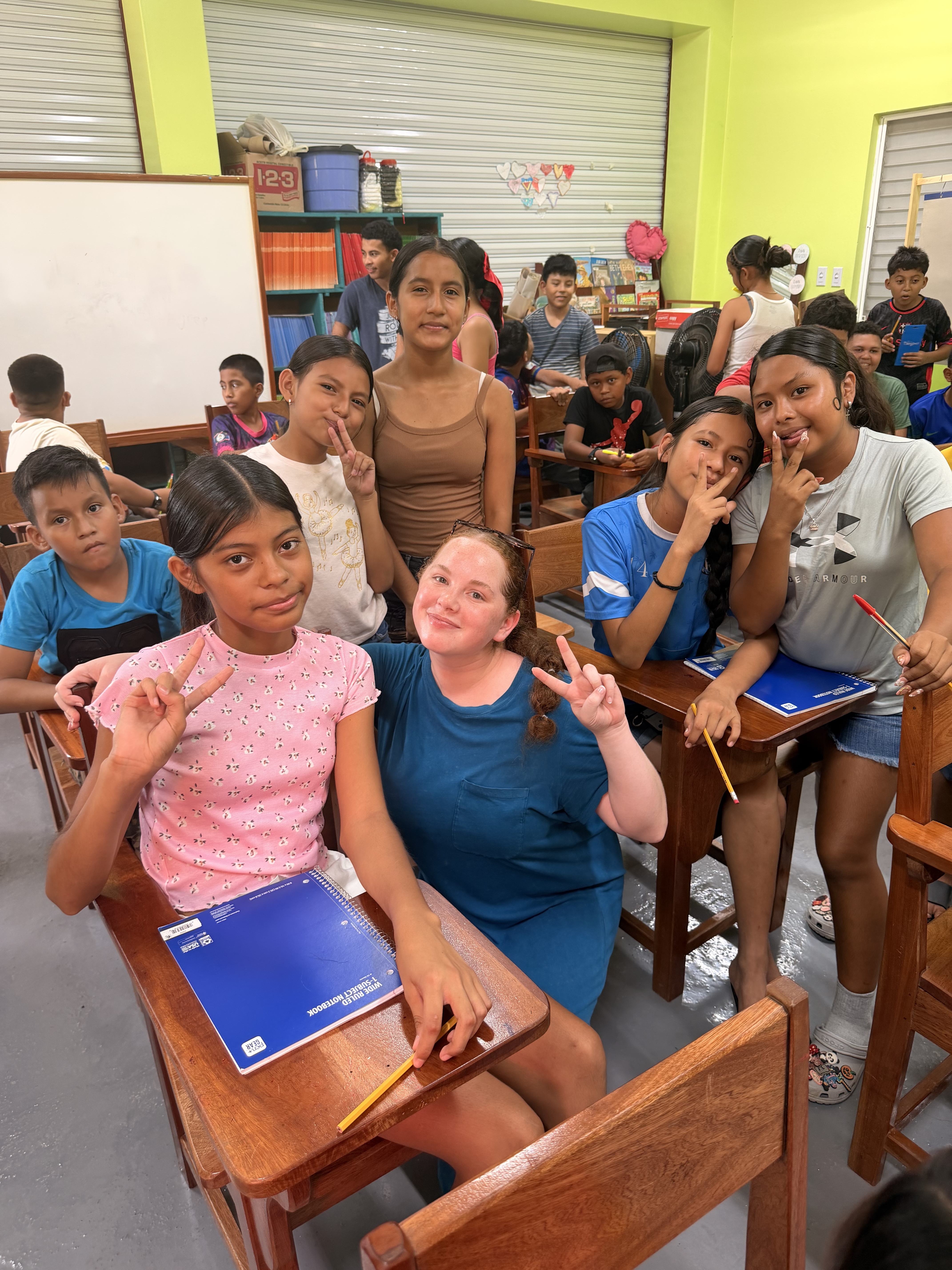 Olivia Phillips learned the teacher she wanted to be while on study program in Belize. students pose in classroom with female teacher