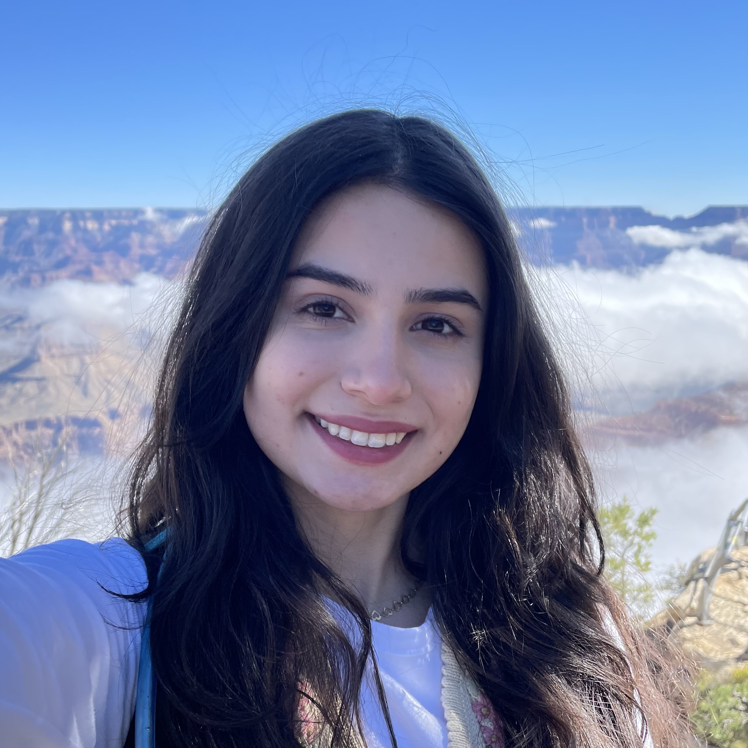Perla Romero smiles at the camera, the Grand Canyon in the background