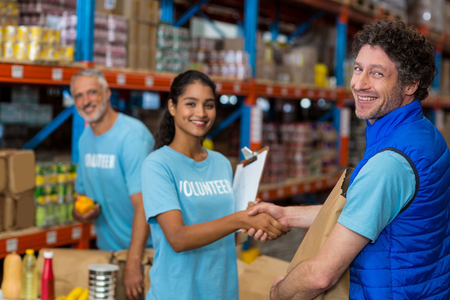 Volunteers at a nonprofit food bank working together and greeting community members.