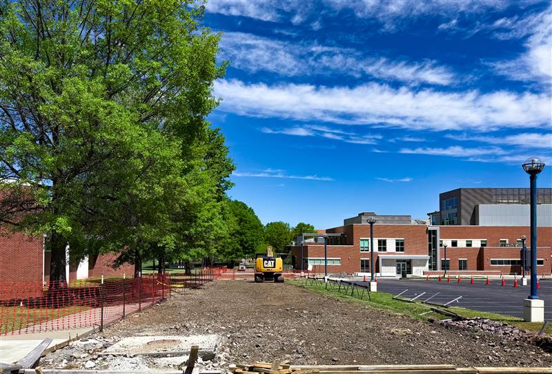 construction equipment removing pavement in front of buildings