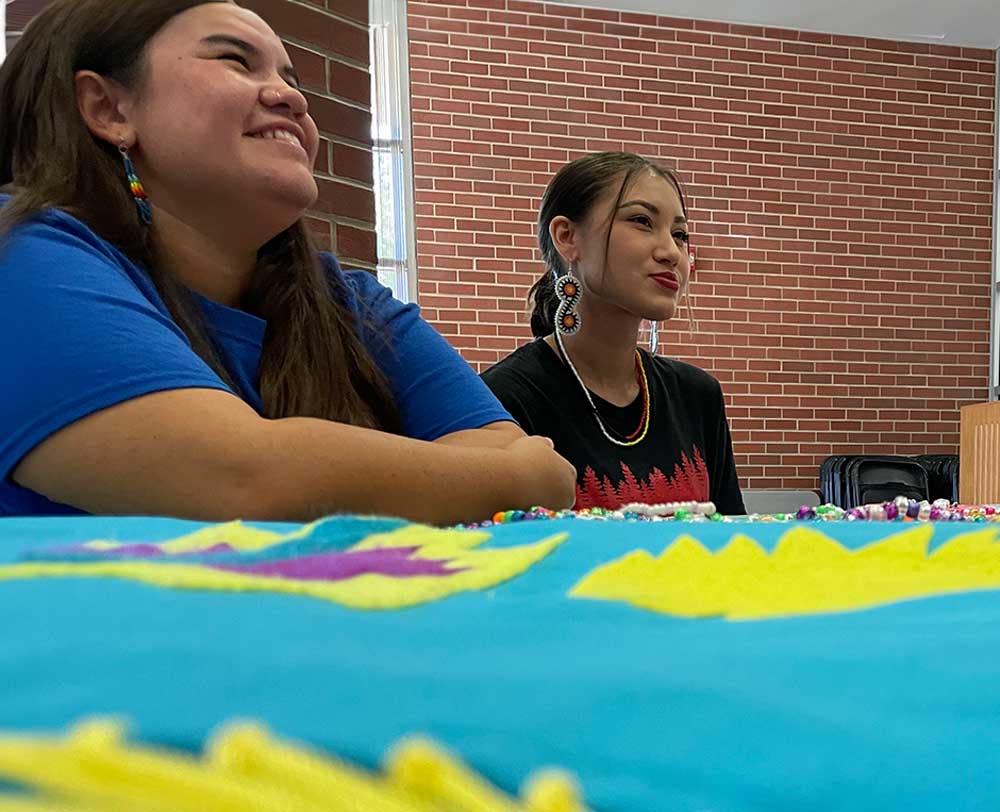 NASA President, Jade Cossey (right), sits with fellow NASA member during Indigenous Peoples' Day, 2023
