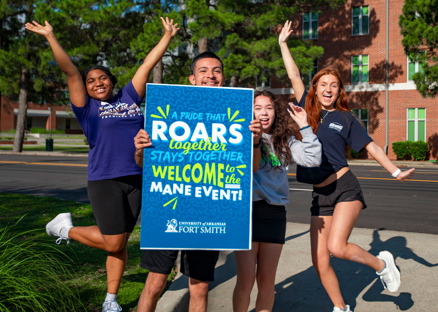 Students cheer with a poster at UAFS Mane Event
