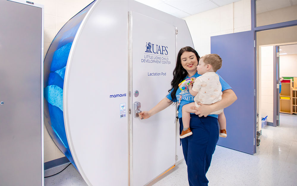 A mom gets ready to take her son into the Mamava Lactation Pod at the University of Arkansas - Fort Smith's Little Lions Child Development Center.