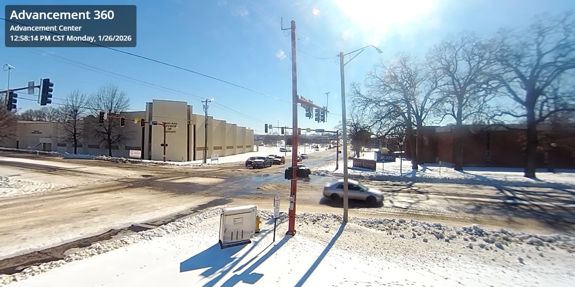 Snow- and ice-covered intersection near UAFS Advancement Center with limited traffic during inclement winter conditions.