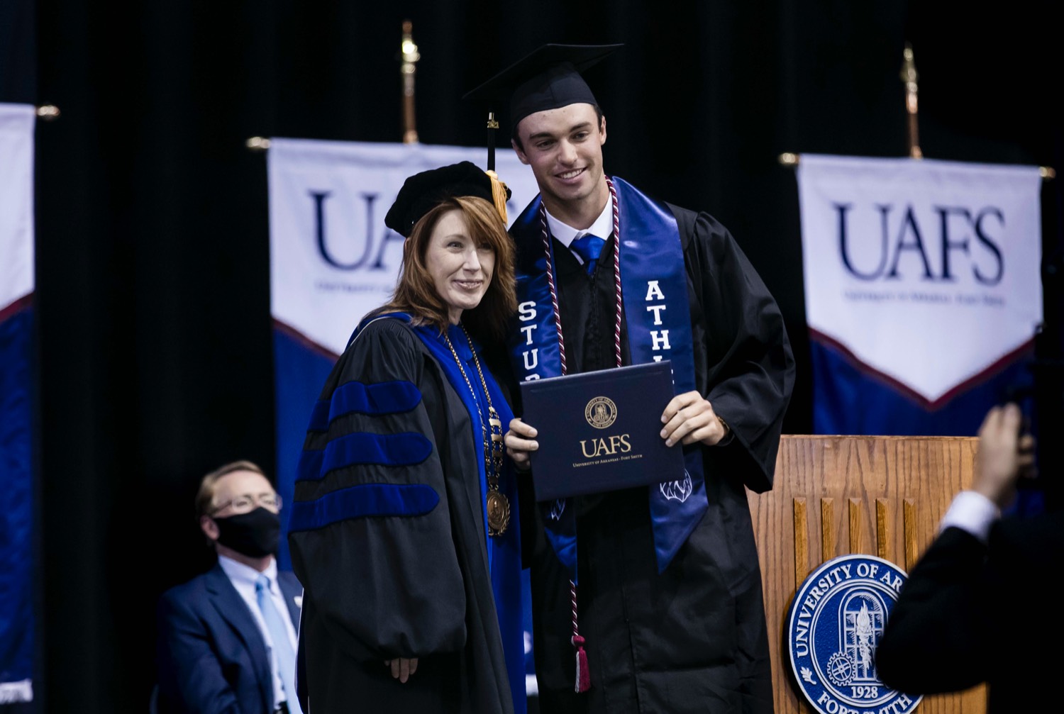 Graduate stands with UAFS Chancellor Terisa Riley on graduation day