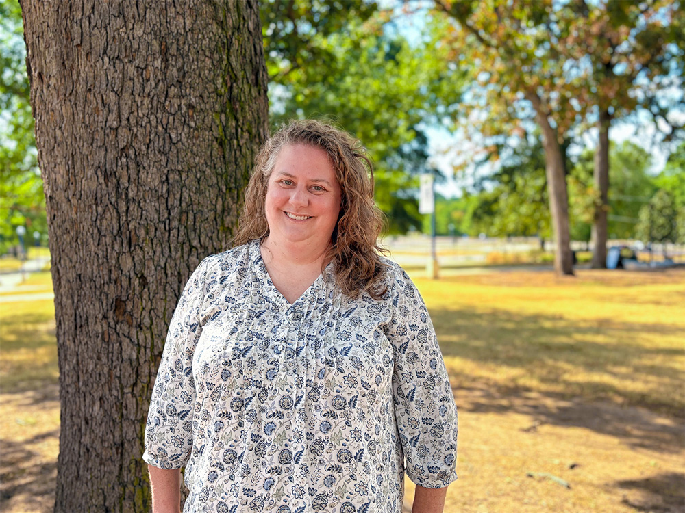 Andrea Burton, director of the Academic Success Center, stands beneath a tree outside of the Vines Building where the ASC is located.