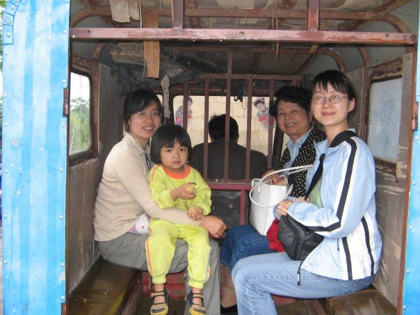 Lee, right, poses with her mother, as Tang holds her small niece on the back of a motorcycle taxi