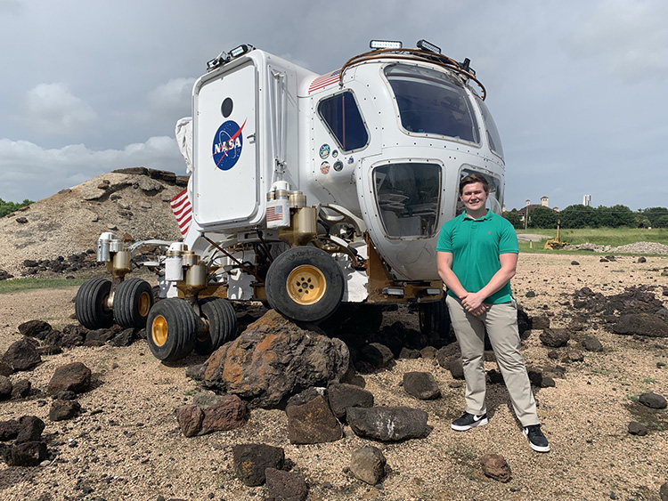 UAFS student stands in front of NASA moonrover