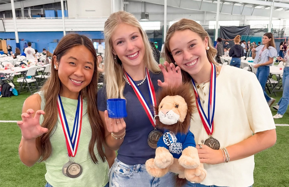Three high school seniors pose with UAFS branded items 