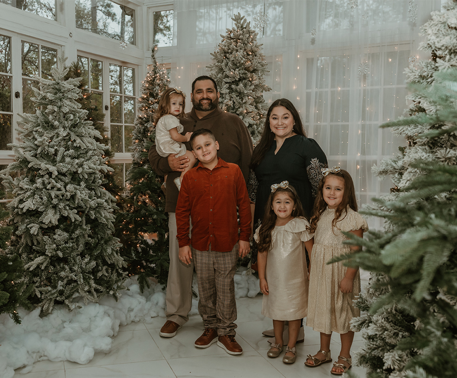 Chris Lopez, left, takes a Christmas photo with his wife and four children