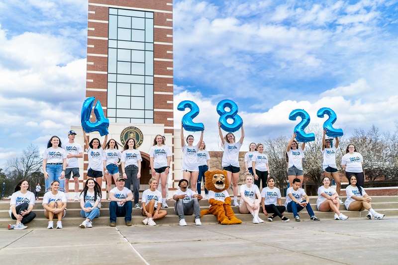 students hold 4, 28. 22, balloons signifying day of giving, April 28, 2022.