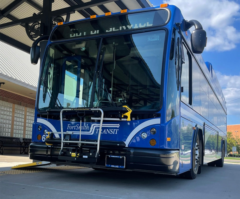 A big blue bus from Fort Smith Transit is parked at the transit station with its wheelchair ramp down