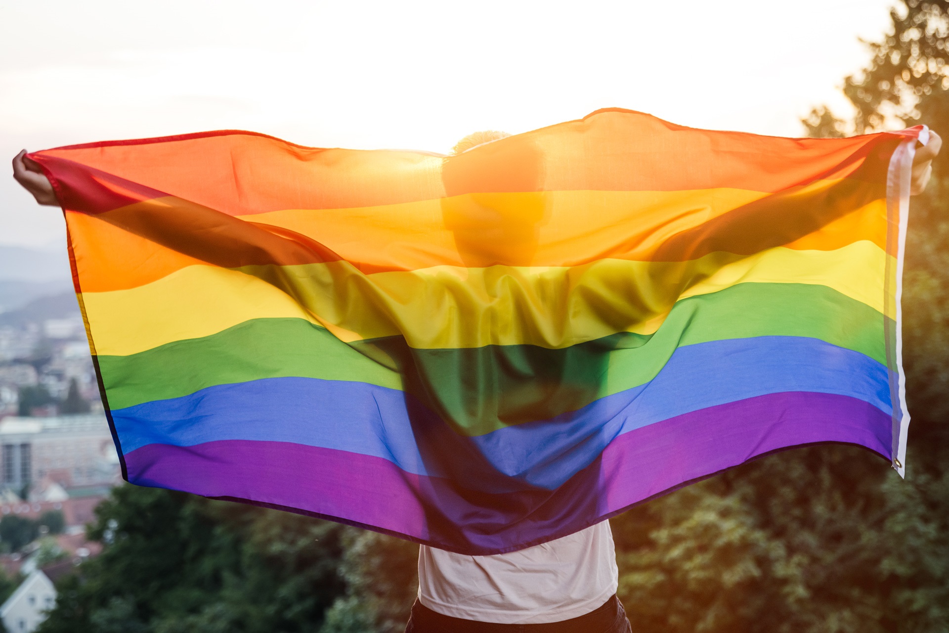 rainbow flag flies above a person