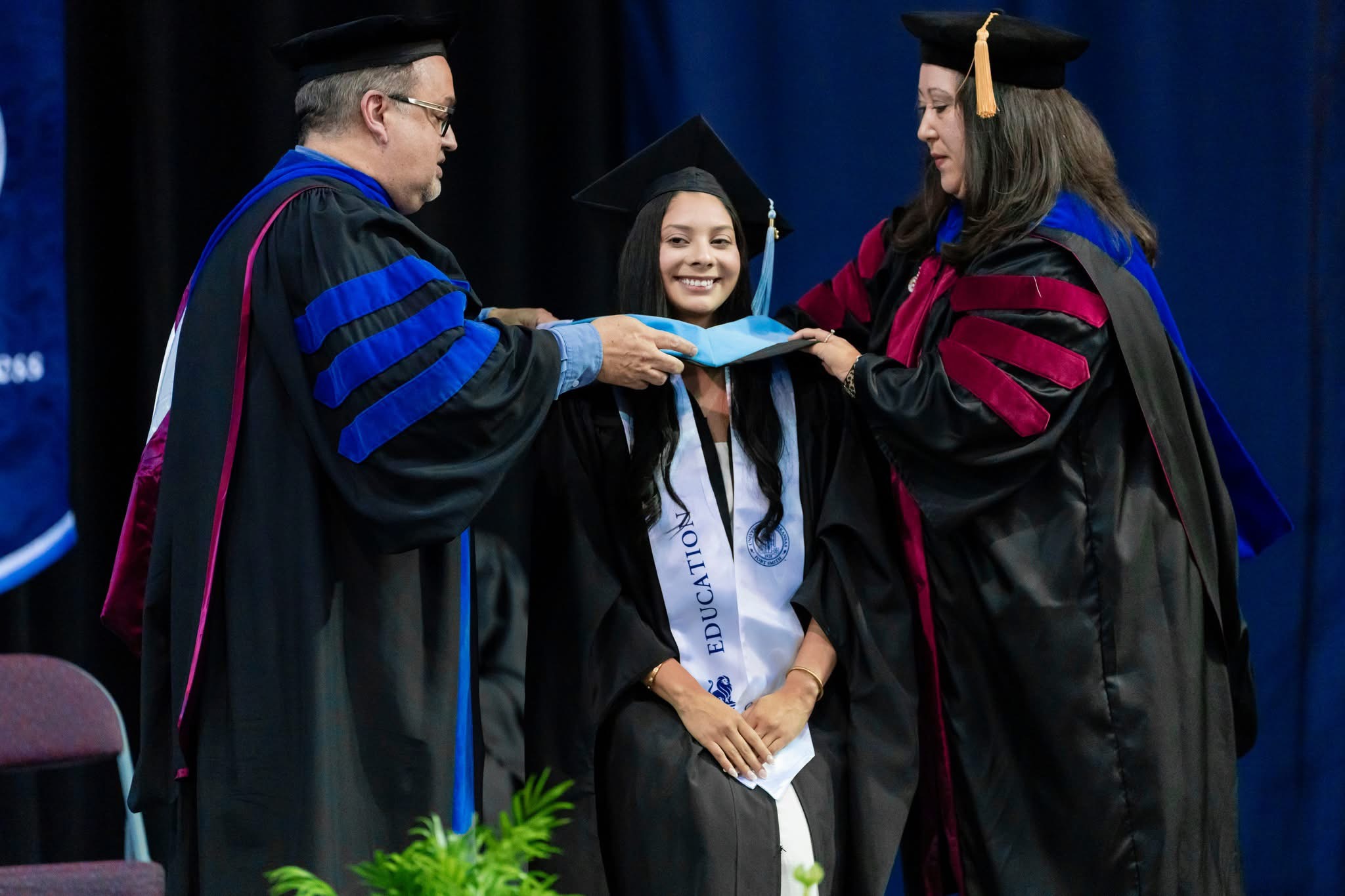 faculty place a master of education hood on a graduate