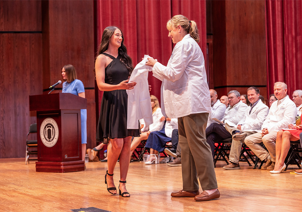 Nayda Barbry, '23, accepts her white coat during A-State's College of Veterinary Medicine White Coat Ceremony on Aug. 8