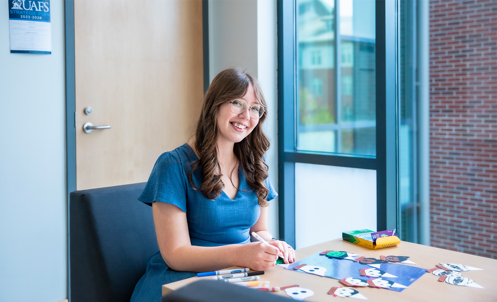 Riplee Breeden, an RA in the Lion's Den, works on Halloween-themed door decks.