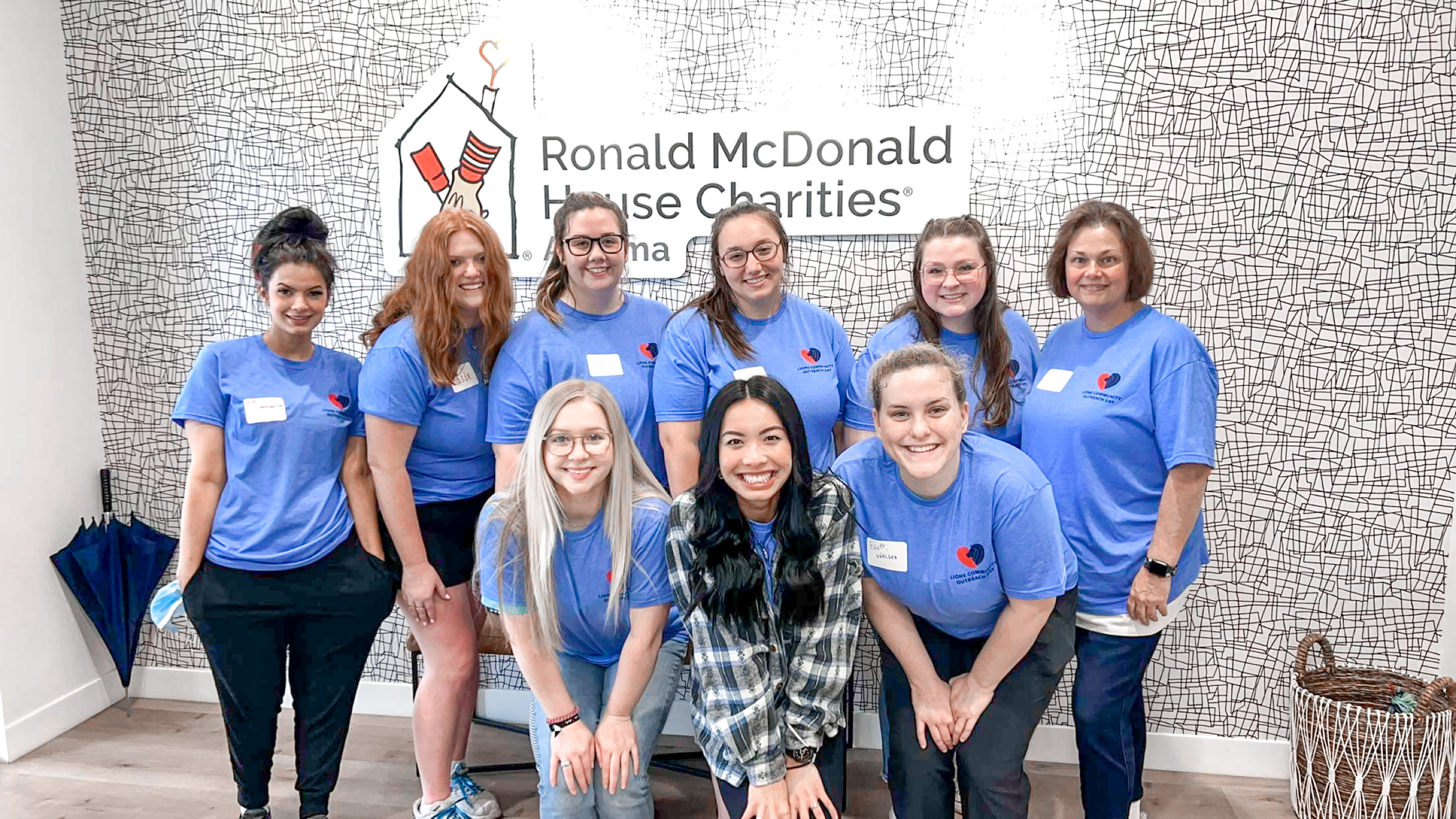 students pose in front of a Ronald McDonald House sign