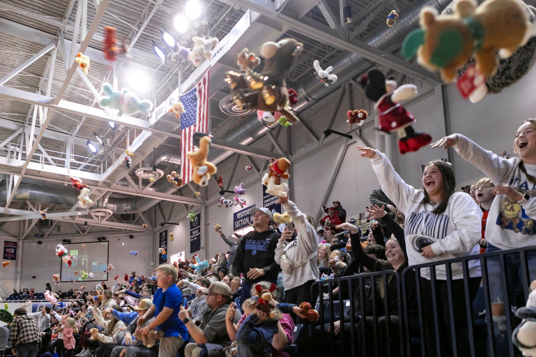 people throwing small plush toys