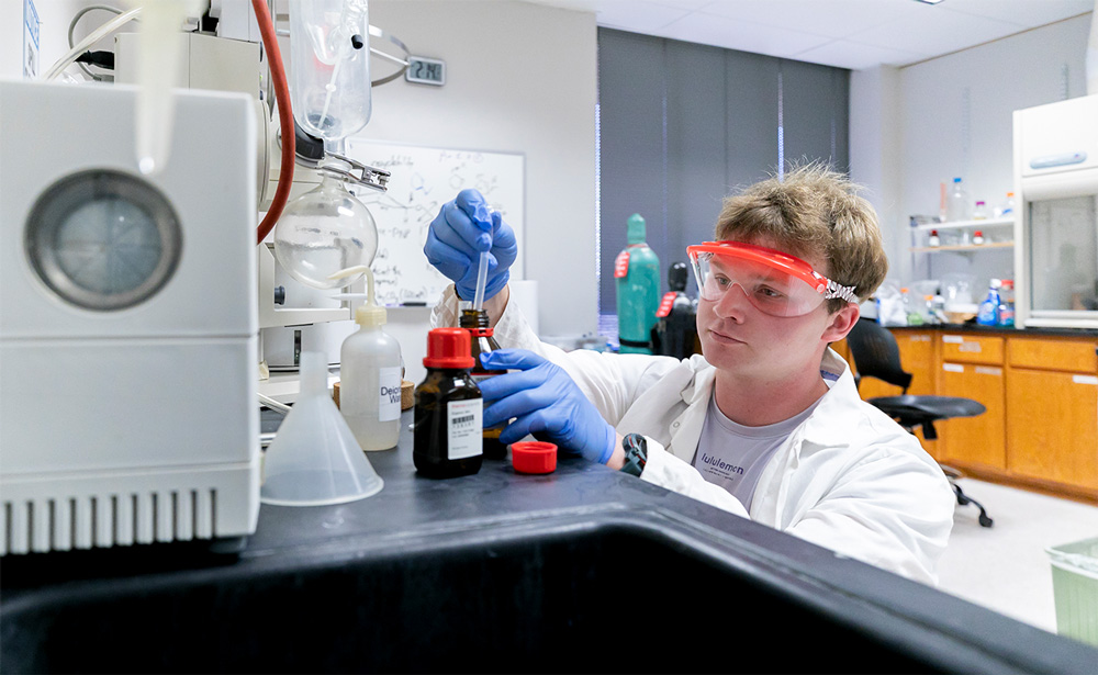 Seth Fields carefully measures out the organic solvent he researched with Dr. Jordan Mader, an associate professor of chemistry.