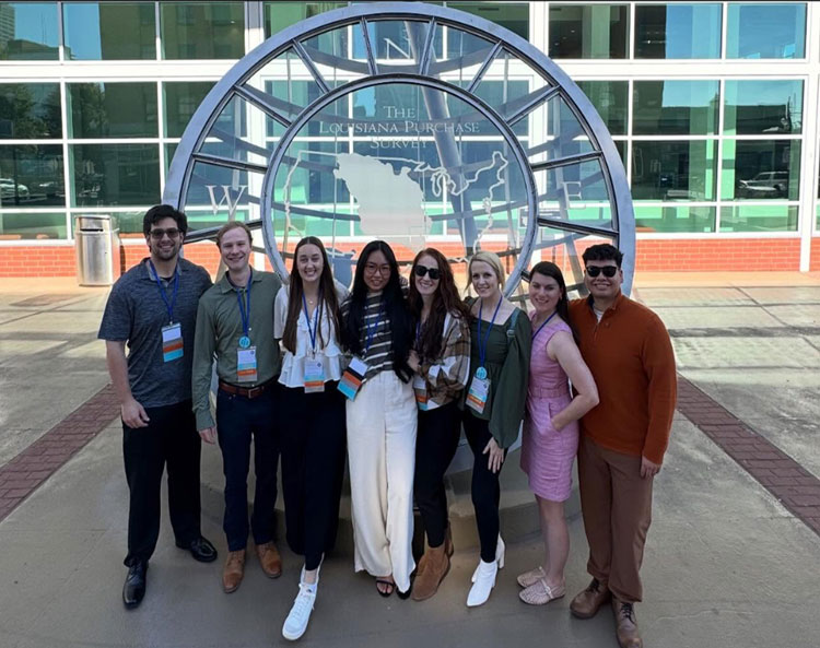 Eight nursing students from UAFS stand together in front of the "Straight Lines on a Round World" sculpture in Little Rock, Arkansas, at the Statehouse Convention Center.