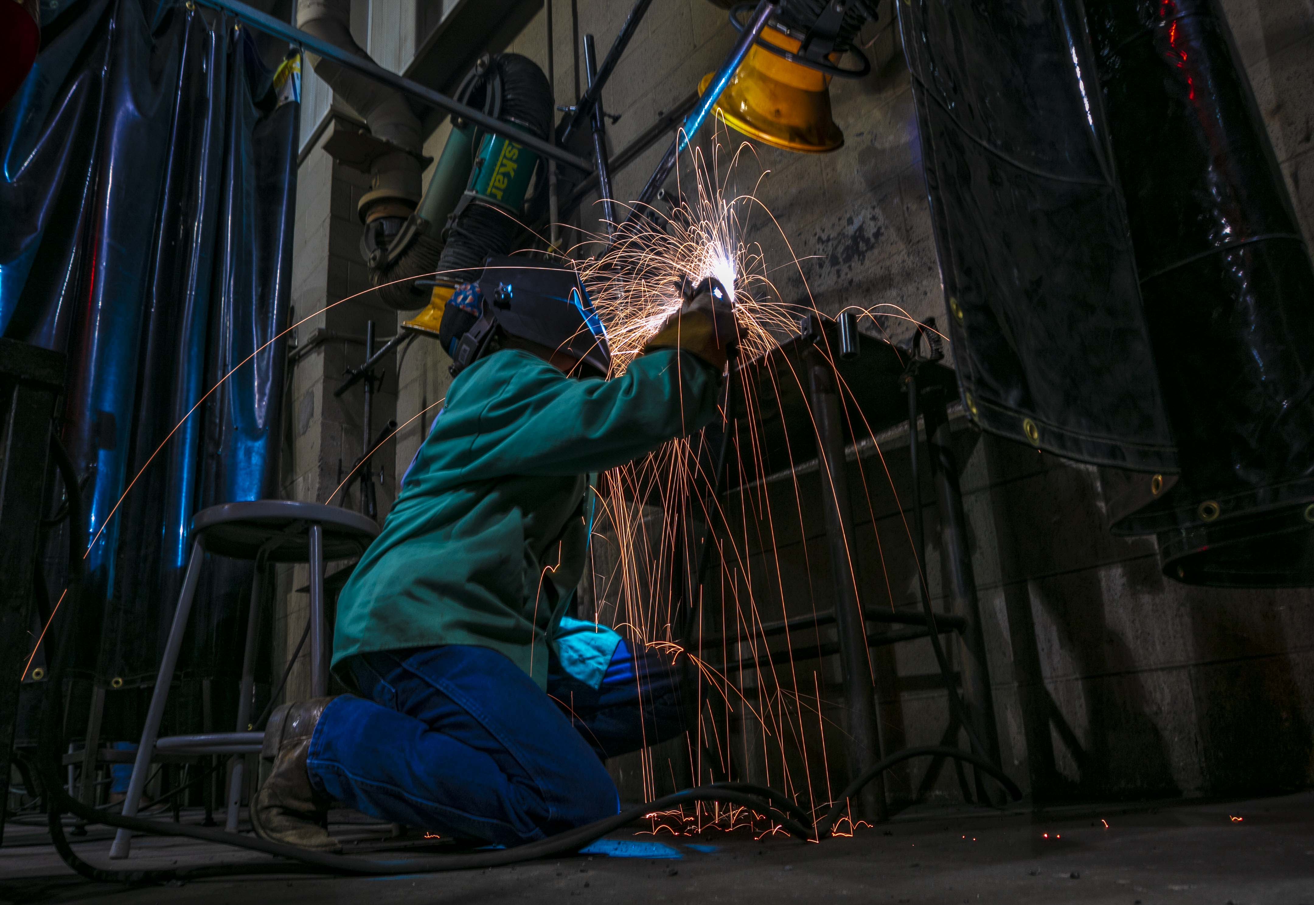 A student welds pieces of metal.