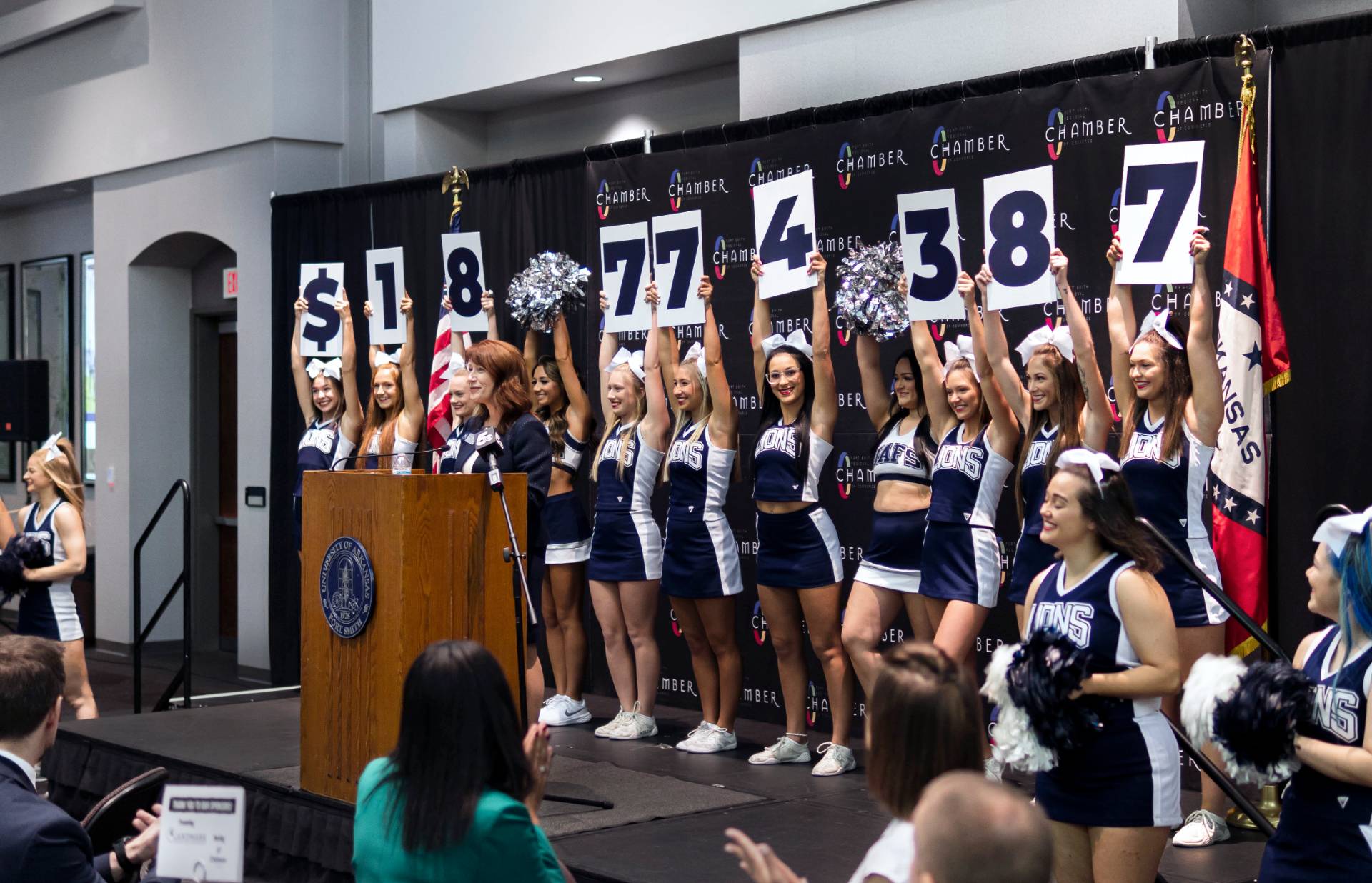 Cheer and Pom hold up sighs stating $18774387 as Chancellor Riley announces the largest gift in university history