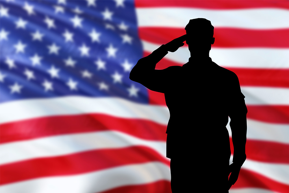 Image of an American Flag with the silhouette of a soldier saluting. 