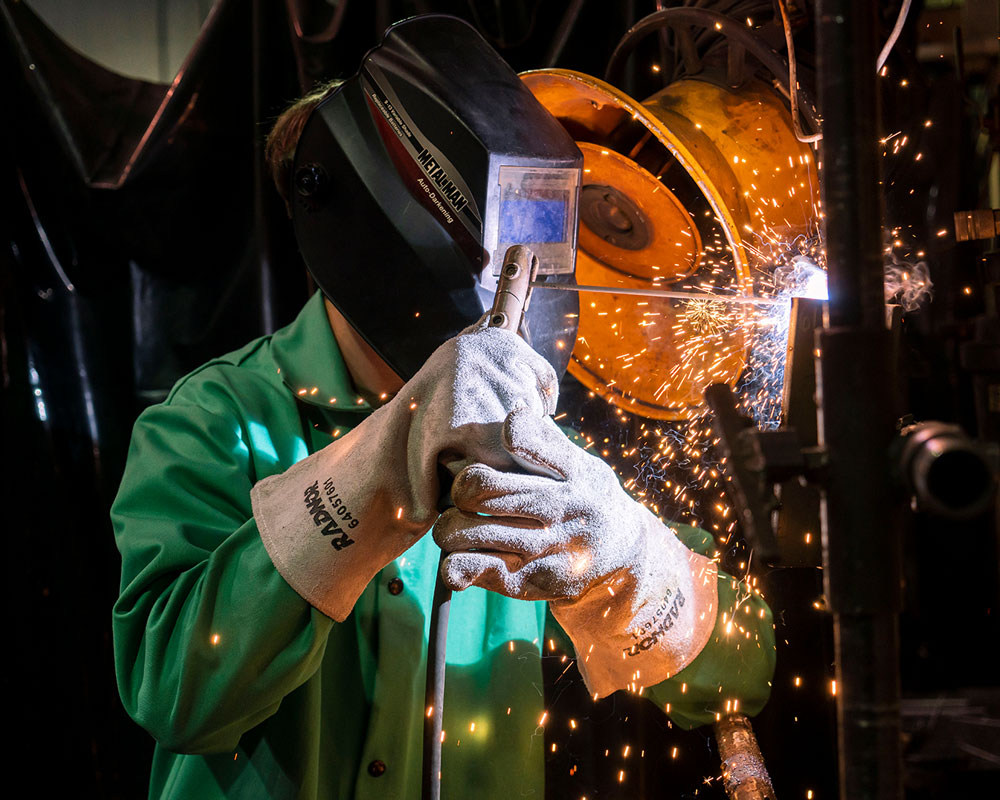 A student carefully welding a T-joint