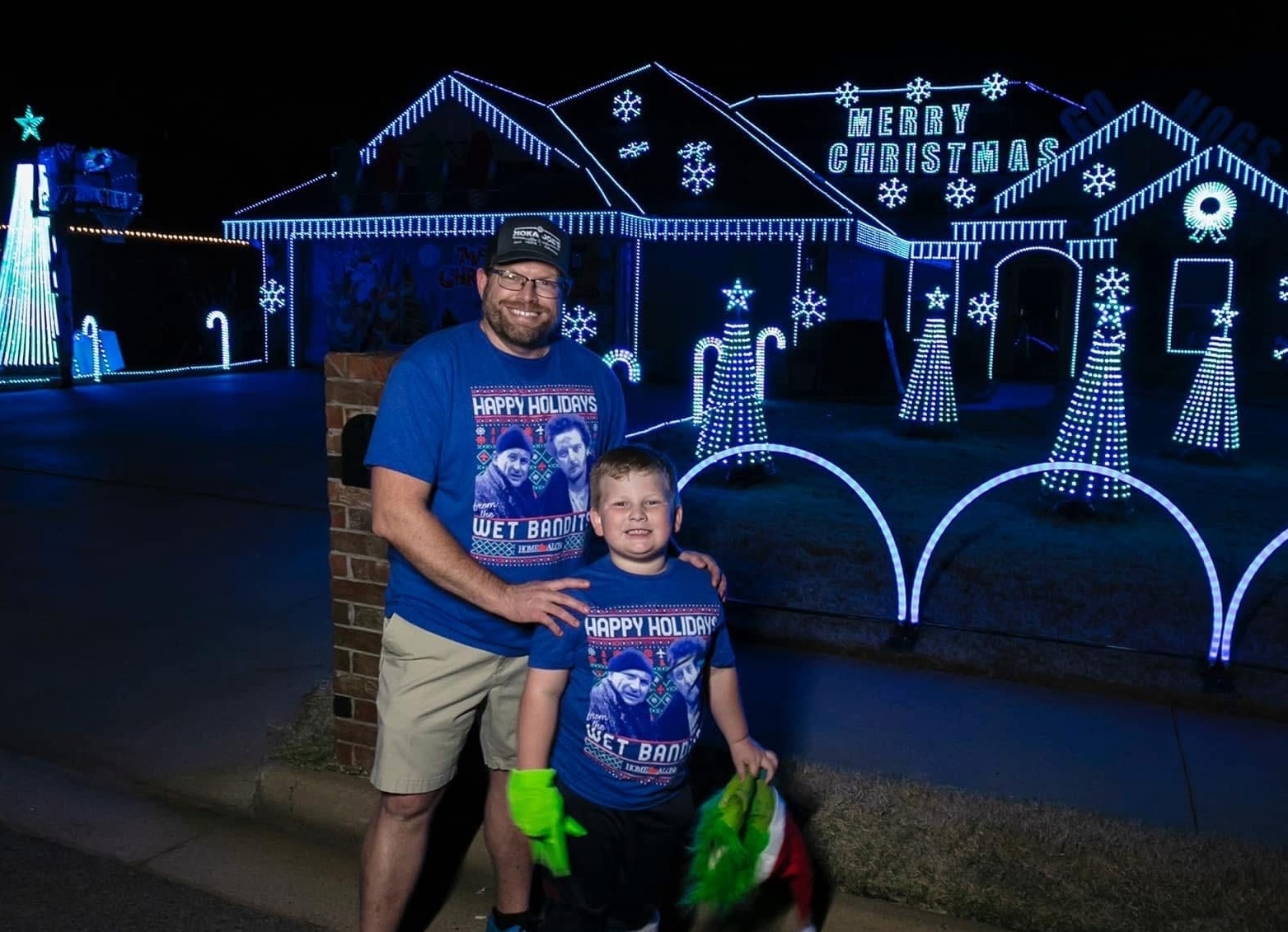 UAFS alum Kyle Speegle and his son pose in front of their Extreme Light Show